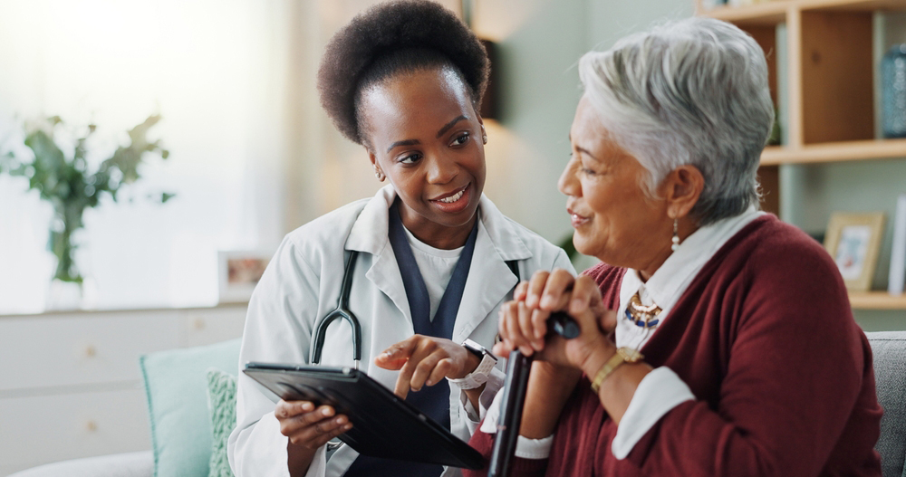 A health care provider showing a patient a tablet.